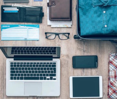 Laptop avec portable tablette, chemises, valises, papiers et billet avion